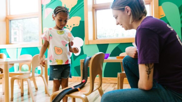 Kid and woman using a marble run