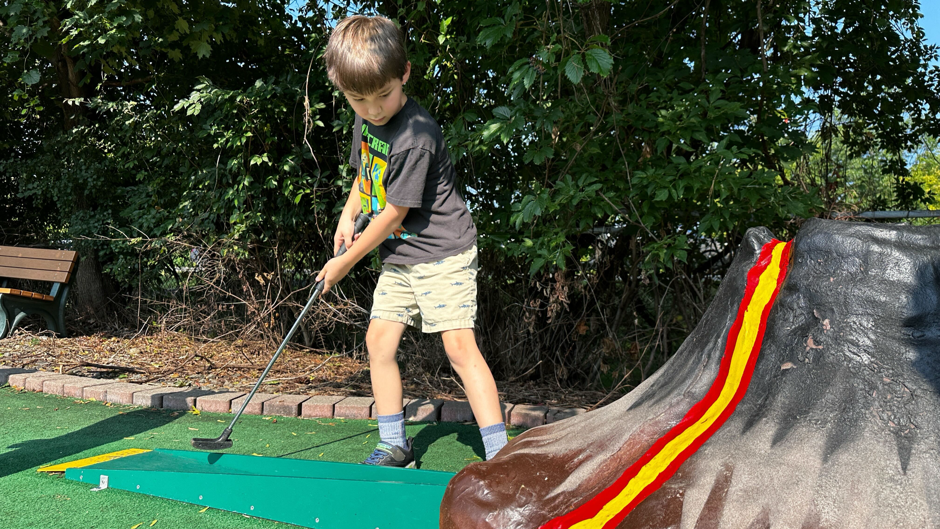 Kid playing mini golf