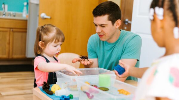 A child and parent experimenting with objects in water